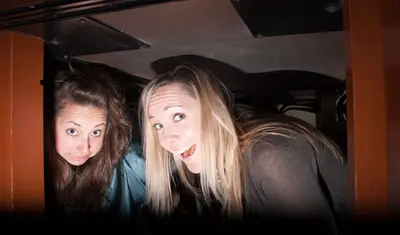 Two people taking shelter under a desk during the Great Shakeout drill