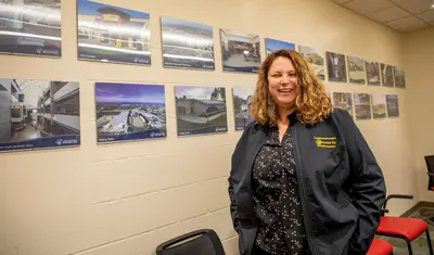 Construction manager standing in front of a wall of photos