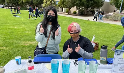 Two students at a table at the BBQ | Photo by Walter Ryce