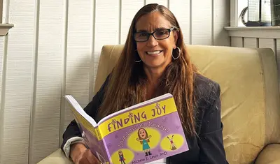 Michelle Lewis flips through her book Finding Joy