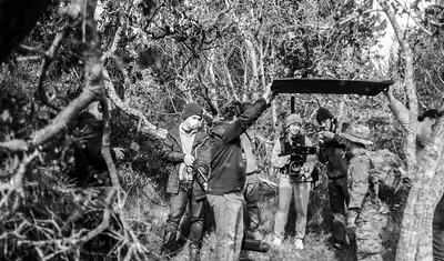 group of students in the woods filming