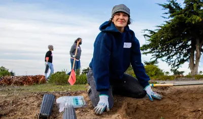 Lacey Raak planting coast live oak trees during the Habitat Restoration and Tree Planting event