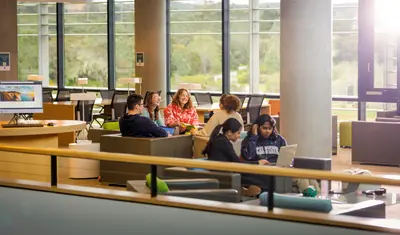 The University Communications team meeting in the library