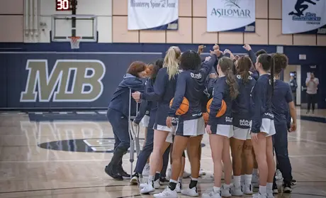 Women's basketball athletes huddling