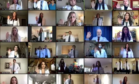 Physician assistant students raise their right hands while reciting an oath during the virtual White Coat Ceremony on Feb. 13.