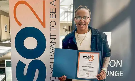Basketball player holding WBCA certificate