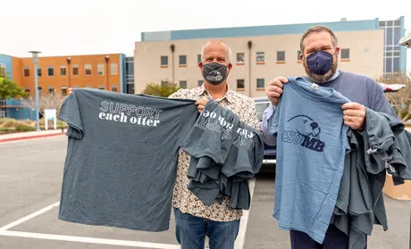 Photo: Chip Lenno and Andrew Drummond holding t-shirts that say 