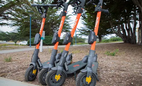 Spin scooters stand ready for riders outside the Alumni and Visitors Center on campus.