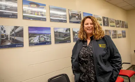 Construction manager standing in front of a wall of photos