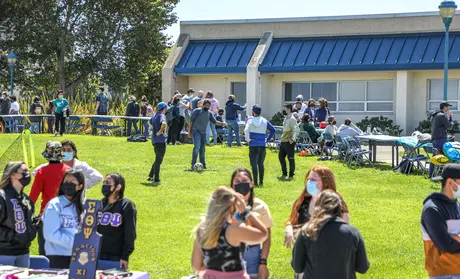 Photo: Students lining up at club and organization tables in the quad during the Otter Showcase event