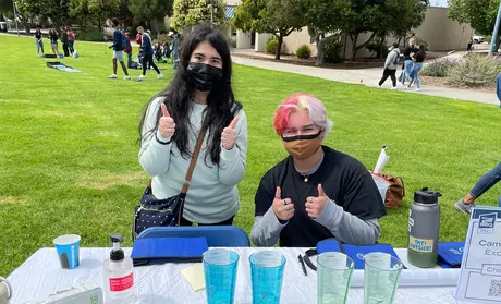 Two students at a table at the BBQ | Photo by Walter Ryce