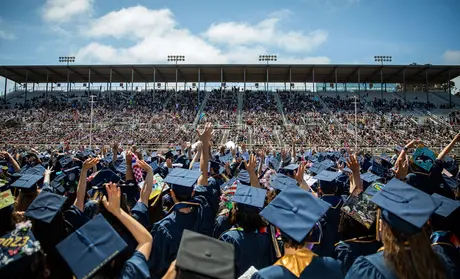 Graduating students wave to their families during the 2023 Commencement at the Salinas Sports Complex. | Photo by Brent Dundore-Arias