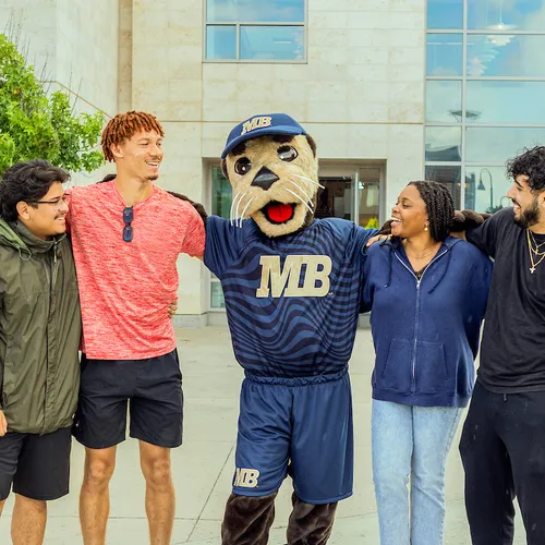 Monte hanging out with a group of students in front of the library