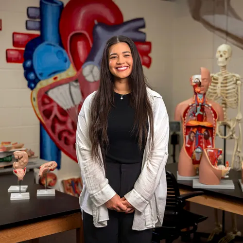 A student standing for a portrait in a classroom.