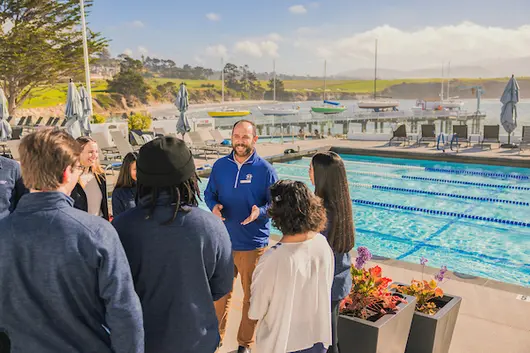 Students with Pebble Beach employee at Pebble Beach in Carmel