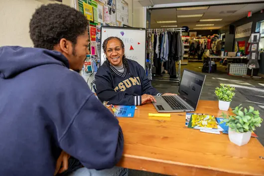 A professor showing off their computer screen to a student