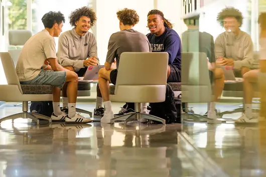 Male students sitting in the business lounge conversing