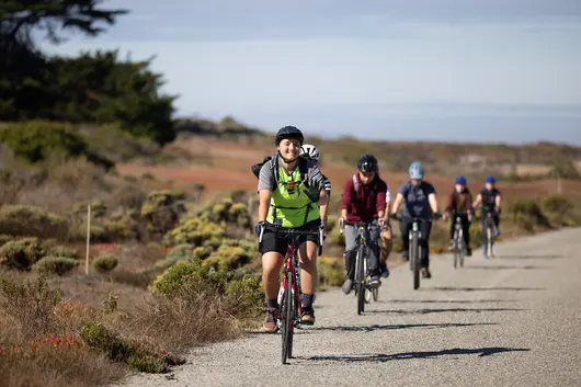 Students bike riding along the coast.