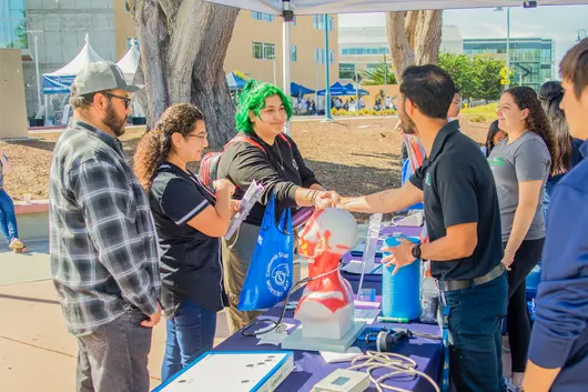 Students interacting with staff during tabling