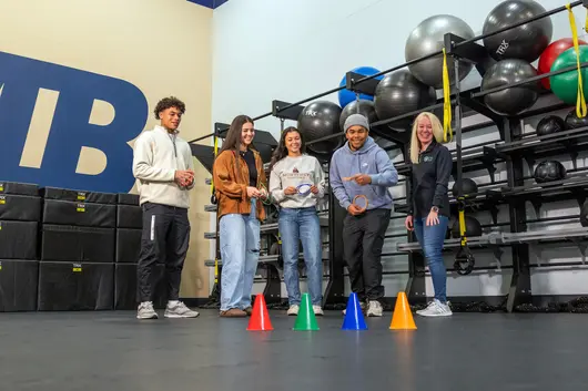 Group of people playing a game together in the gym.