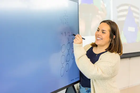 A student writing on the digital board
