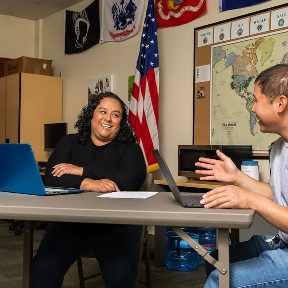Veteran talking with a student in a classroom.
