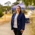 Student in a blazer standing and smiling outside for a portrait.