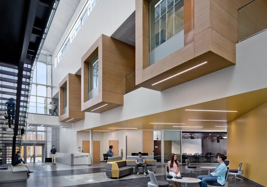 Students gather and study in a bright, modern atrium at California State University, Monterey Bay (CSUMB). The open space features wood-accented architecture, natural light, and collaborative seating areas, creating a welcoming environment for learning and connection.