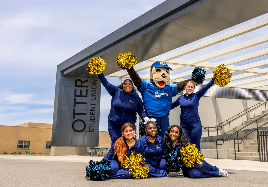 Cheering team with the Mascot in front of the Otter