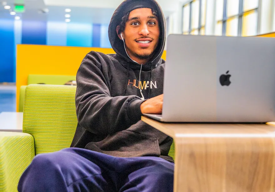 Student on a laptop in a seating area