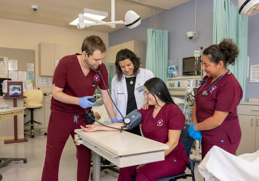 A group of three students and a professor doing a demonstration on how to use equipment