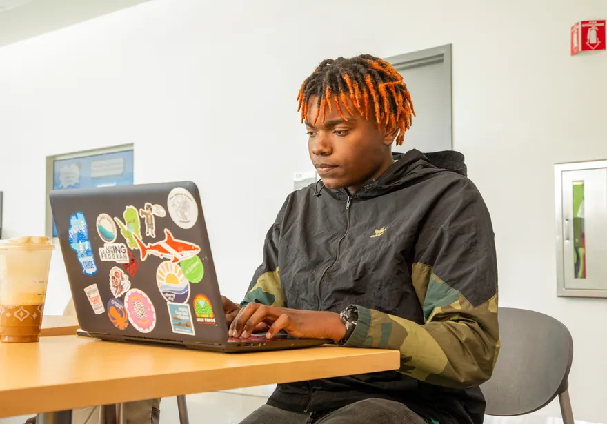 Student looking at a laptop on a desk