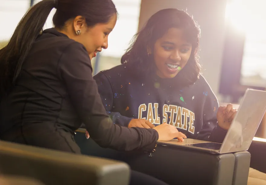 Two students looking at laptop together