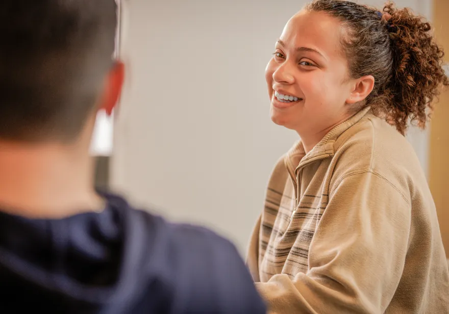 Female student smiling at another student