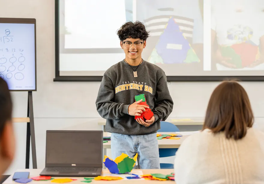 A student presenting in front of the classroom