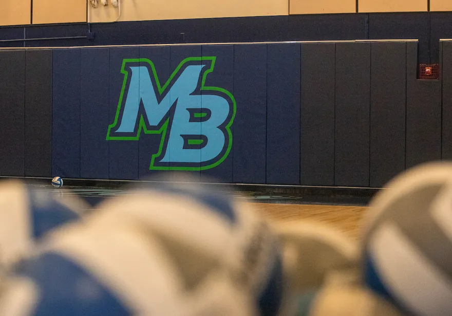 CSUMB Logo with volleyballs in the foreground