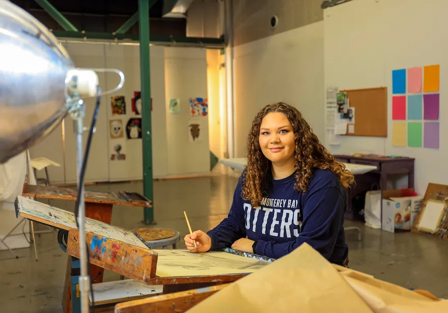 A student works on a drawing in an art studio, showcasing creativity and hands-on learning.