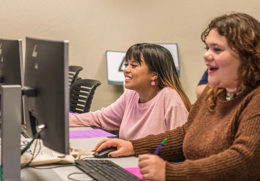 two students on computers for orientation