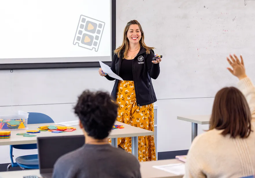 Professor presenting and speaking in front of a classroom of students