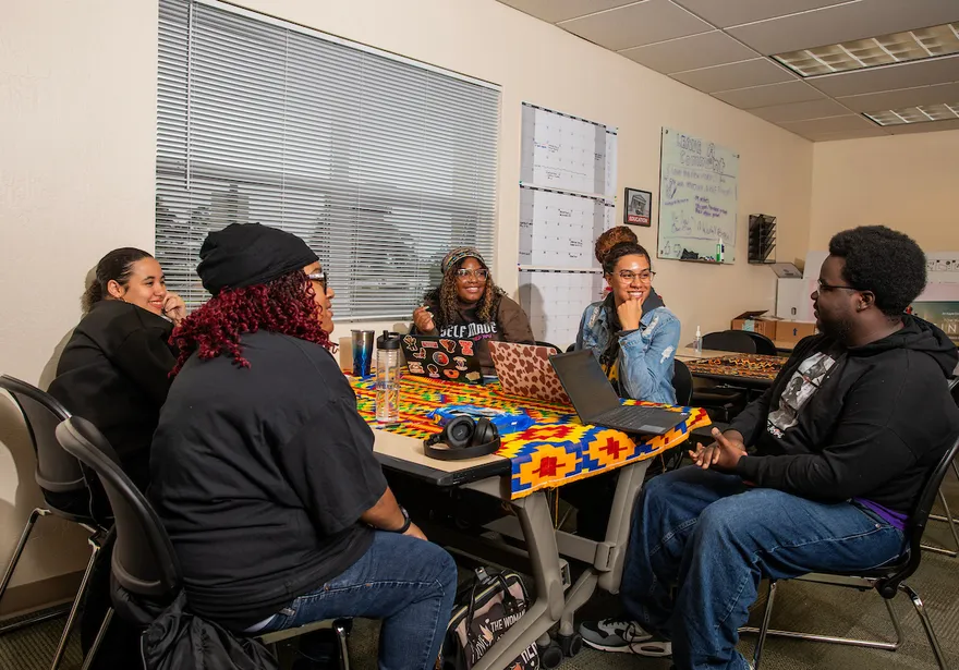 A group of students sitting at a table at the Helen Rucker Center.