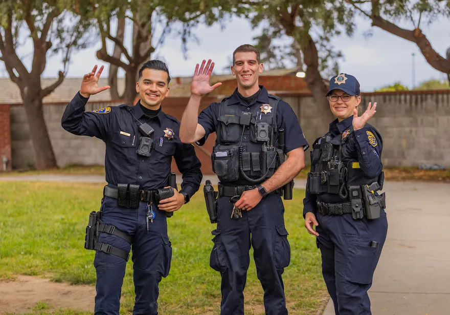 Members of the ���ӽ紫ý University Police Department and CSOs pose in front of a police vehicle