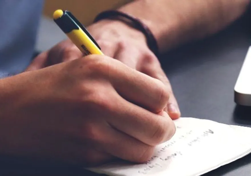 Photo of student writing notes.