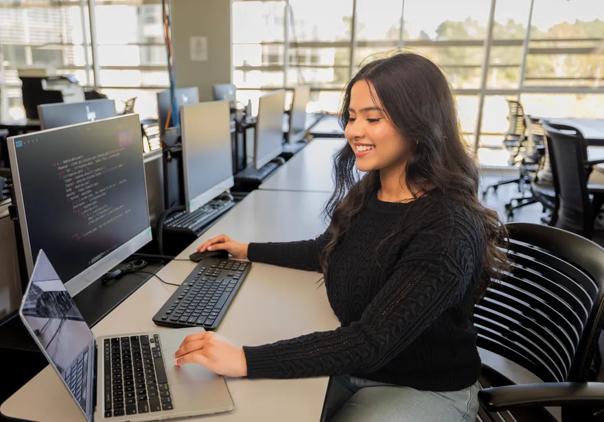 A student sitting down inside a computer lab in the business and information technology building