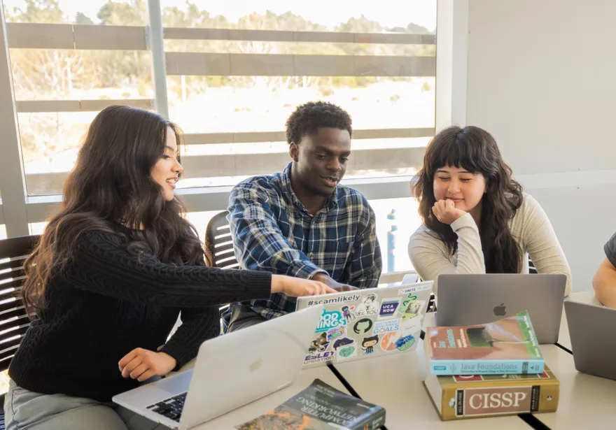 A group of students collaborating in a computer lab in the buissness and information technology building