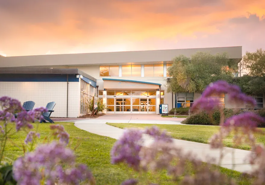 A landscape of a building with a sunset in the background