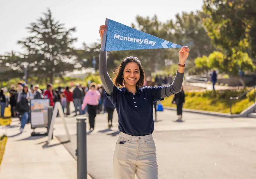 Student holding flag above their head